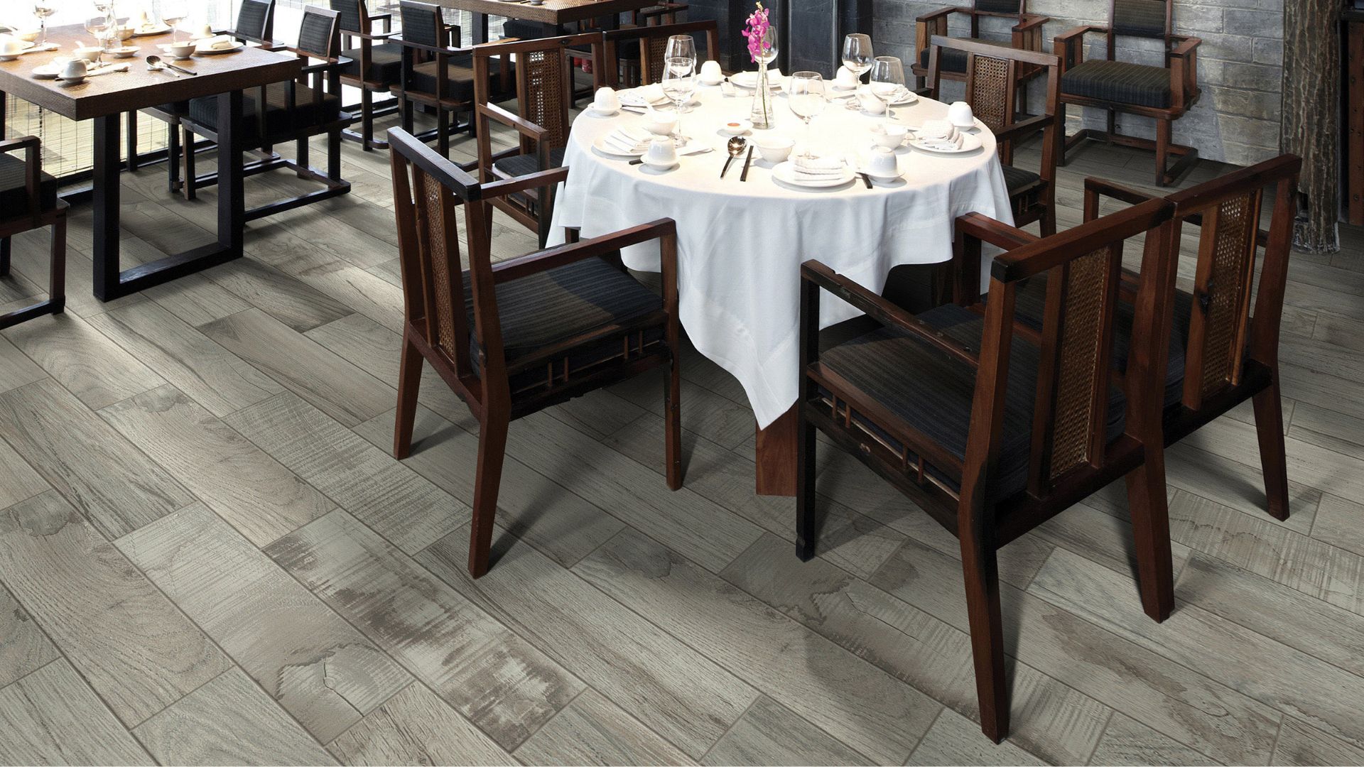 Commercial flooring in a venue with a table with white cloth and wooden chairs